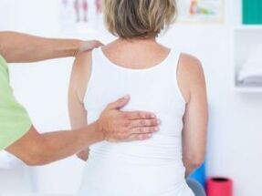 Ein Patient mit Beschwerden über Rückenschmerzen im Schulterblattbereich wird von einem Arzt untersucht. 